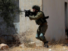Um soldado israelita aponta a arma a manifestantes palestinos em Kafr Qaddum, Cisjordânia ocupada, 12 de Julho de 2019
